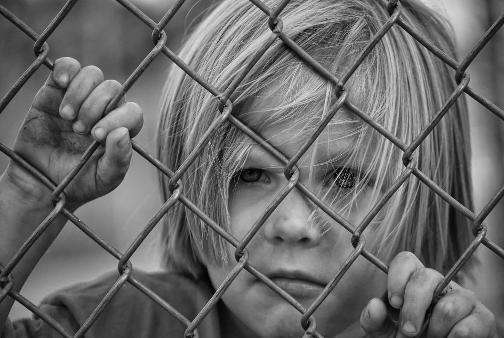 boy behind fence