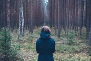 woman in a coat in the forrest